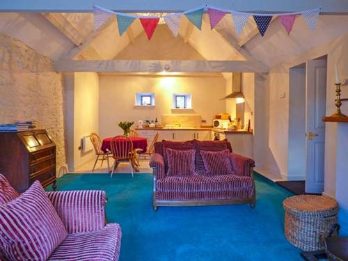 una sala de estar con sofás morados y una mesa. en The Aylesbury Cottage en Dyrham