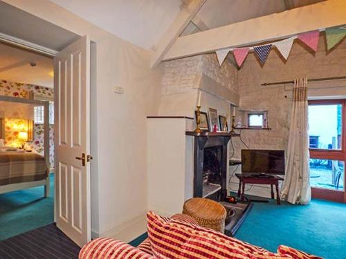 a living room with a couch and a fireplace at The Aylesbury Cottage in Dyrham