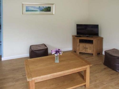 a living room with a vase of flowers on a coffee table at Cwmgilla Farm in Knighton