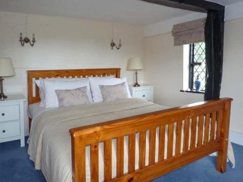 a bedroom with a large wooden bed and a window at Tudor Wing in Chiddingstone