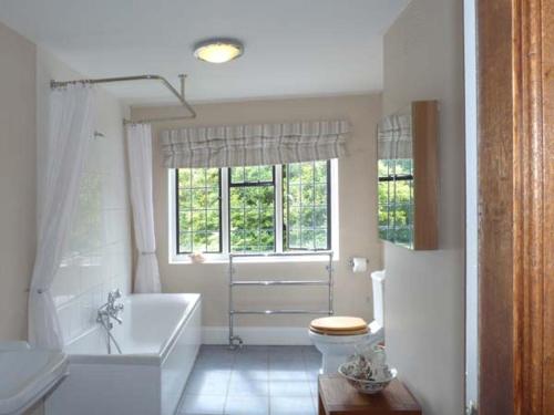 a bathroom with a tub and a toilet and a sink at Tudor Wing in Chiddingstone