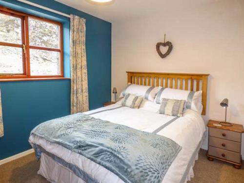 a bedroom with a large bed with blue walls at 4 Adwy'r Nant in Beddgelert