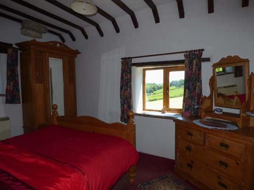 ein Schlafzimmer mit einem Bett, einer Kommode und einem Fenster in der Unterkunft Chevinside Cottage in Hazelwood