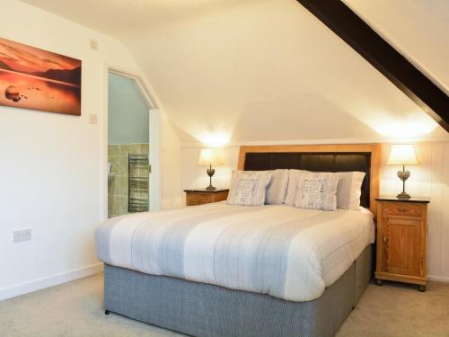 a bedroom with a large bed and a window at Monarfon in Benllech