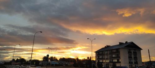 a building with a sunset in the background at Casa del Kayak in Punta Arenas
