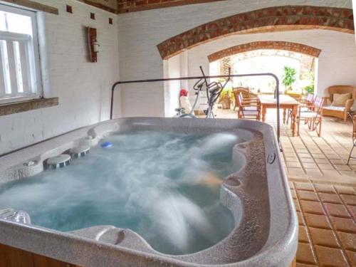 a jacuzzi tub in a house with a patio at Bramhill Barns in Burton Pidsea