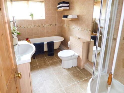 a bathroom with a tub and a toilet and a sink at Ash House in Alton