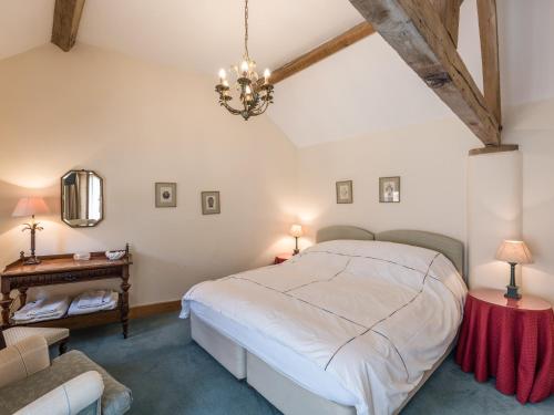ein Schlafzimmer mit einem großen Bett und einem Kronleuchter in der Unterkunft Garden Barn in Highley
