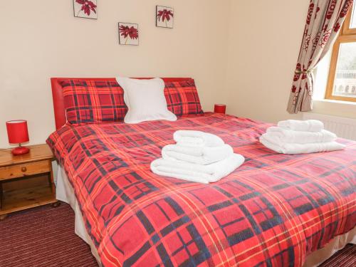 a bedroom with a bed with towels on it at Bishop Cottage in Loftus