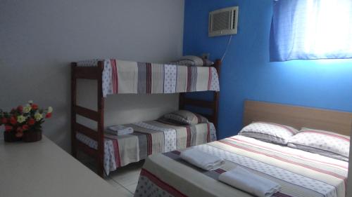 ein Schlafzimmer mit zwei Etagenbetten und einem Fenster in der Unterkunft Hotel Pousada Executiva Itabuna in Itabuna