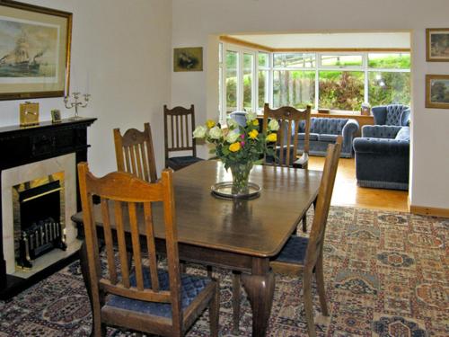 a living room with a wooden table with flowers on it at Homestone Farm in Drumlemble