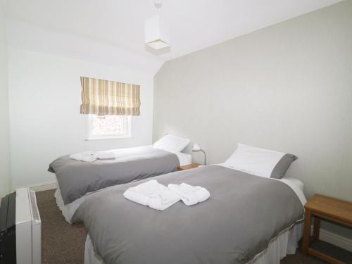 2 letti in camera d'albergo con asciugamani di William Court Cottage a Santon Bridge