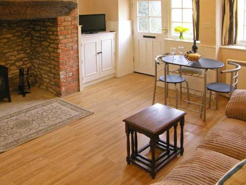 un salon avec une table et un canapé dans l'établissement Candy Cottage, à Bradford Abbas