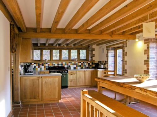 uma grande cozinha com armários de madeira e uma bancada em Hiraeth em Penybont