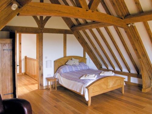 a bedroom with a wooden bed in a attic at Hiraeth in Penybont