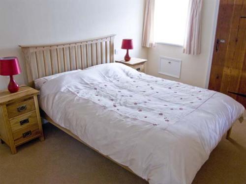 sypialnia z białym łóżkiem i dwoma stołami z lampkami w obiekcie The Sun House w mieście Ferrensby