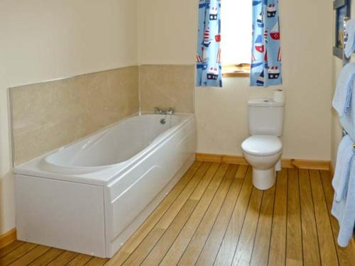 a bathroom with a white tub and a toilet at Bruach Gorm Cottage in Grantown on Spey
