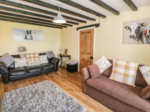 a living room with two couches and a couch at Ty Fferm Bodlasan in Llanfachraeth
