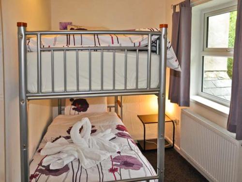 a bedroom with a bunk bed with towels on it at Hendre Aled Cottage 1 in Llansannan