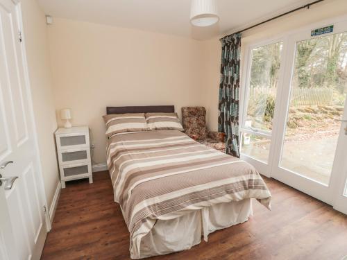 een slaapkamer met een bed en een raam bij No 3 Low Hall Cottages in Scalby