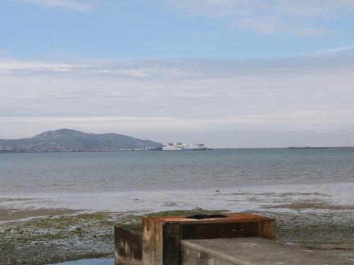 a view of the ocean with a island in the distance at Ty Fferm Bodlasan in Llanfachraeth