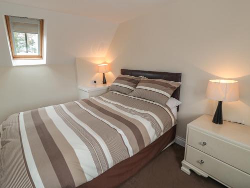 a bedroom with a bed and a nightstand with two lamps at No 2 Low Hall Cottages in Scalby