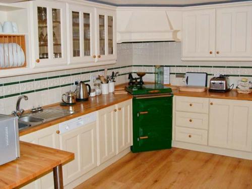 eine Küche mit weißen Schränken und einem grünen Kühlschrank in der Unterkunft 1 The Old Methodist Chapel in Rosedale Abbey