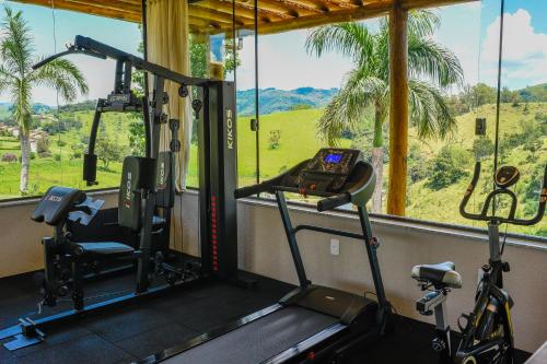 a gym with two exercise bikes in front of a window at Pousada Estância das Montanhas in Águas de Lindóia