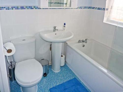 a bathroom with a white toilet and a sink at Loningside in Wombourn