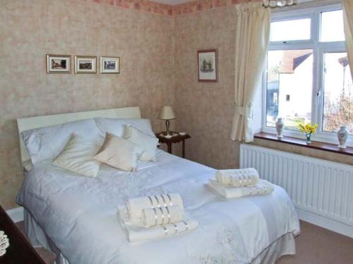 um quarto com uma cama branca com duas almofadas em Loningside em Wombourn