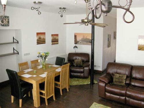 a living room with a table and chairs and a couch at The Reiver's Retreat in Haltwhistle