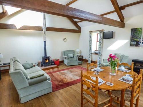 a living room with a table and a fireplace at Muncaster View in Drigg