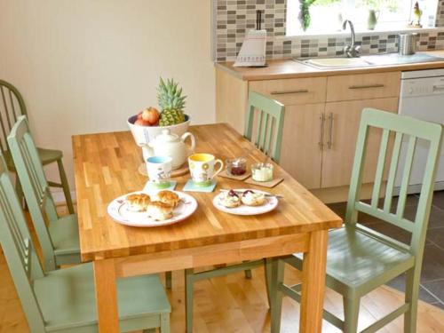 a wooden table with plates of food on it in a kitchen at 15 Forest Park Lodges in High Bickington