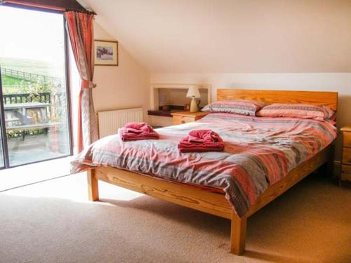 una camera da letto con un letto con asciugamani rossi di Uplands a Compton
