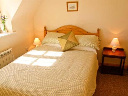 a bedroom with a large bed with two lamps on it at The Cygnet in Haselbury Plucknett