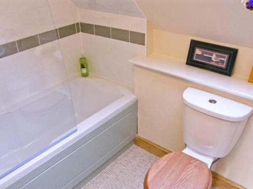 a bathroom with a white toilet and a bath tub at The Cygnet in Haselbury Plucknett