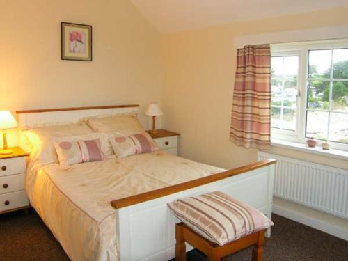 a bedroom with a white bed and a window at Glan Y Don Bach in Abersoch