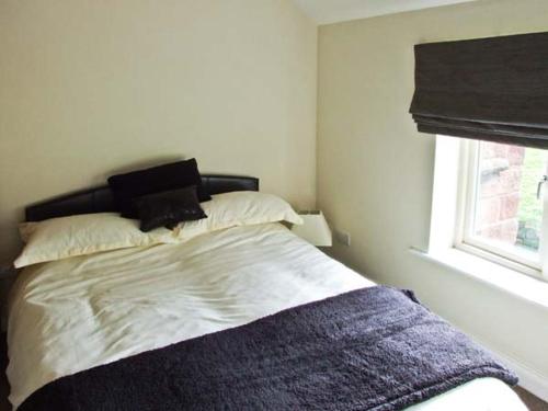 een slaapkamer met een bed met een deken erop bij 1 Cabin Knoll in Stanton