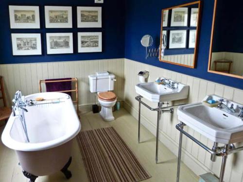 a bathroom with two sinks and a tub and a toilet at Raceside Farm in Silecroft