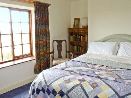 a bedroom with a bed and a window at Coles Cottage in Holsworthy