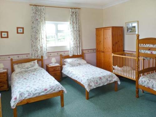 a bedroom with two twin beds and a crib at Stonewind Farm in Freshwater