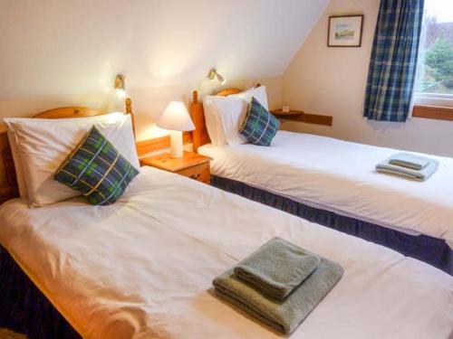 two beds with towels on them in a hotel room at Suil Na Mara in Aultbea