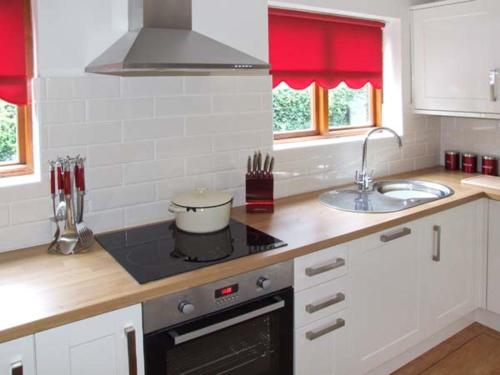 een keuken met een spoelbak en een fornuis bovenste oven bij 9 Bancroft Place in Stratford-upon-Avon