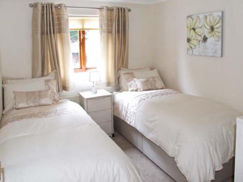1 dormitorio con 2 camas y ventana en 9 Bancroft Place en Stratford-upon-Avon