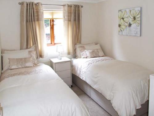 een slaapkamer met twee bedden en een raam bij 9 Bancroft Place in Stratford-upon-Avon