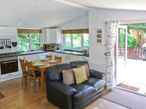 een woonkamer met een bank en een tafel in een keuken bij Top Lodge, 4 Skiptory Howe in Windermere