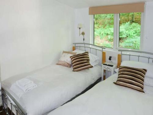 ウィンダミアにあるTop Lodge, 4 Skiptory Howeの窓付きのベッドルームに白いベッド2台が備わります。