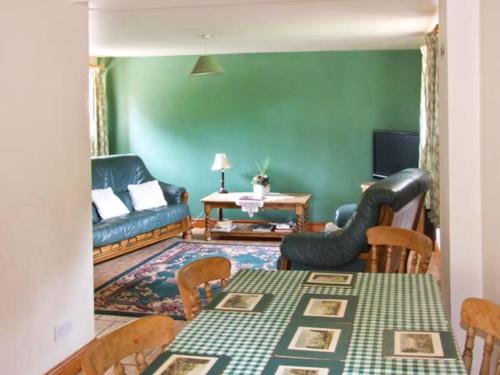 uma sala de estar com um sofá, uma mesa e cadeiras em Horse Shoe Cottage em Bradley in the Moors