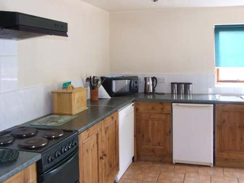 uma cozinha com um fogão e uma bancada em Horse Shoe Cottage em Bradley in the Moors