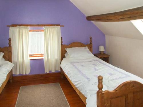 um quarto com uma cama grande e uma janela em Horse Shoe Cottage em Bradley in the Moors